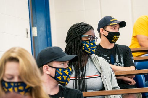 Students in the classroom wearing masks, looking towards their instructor